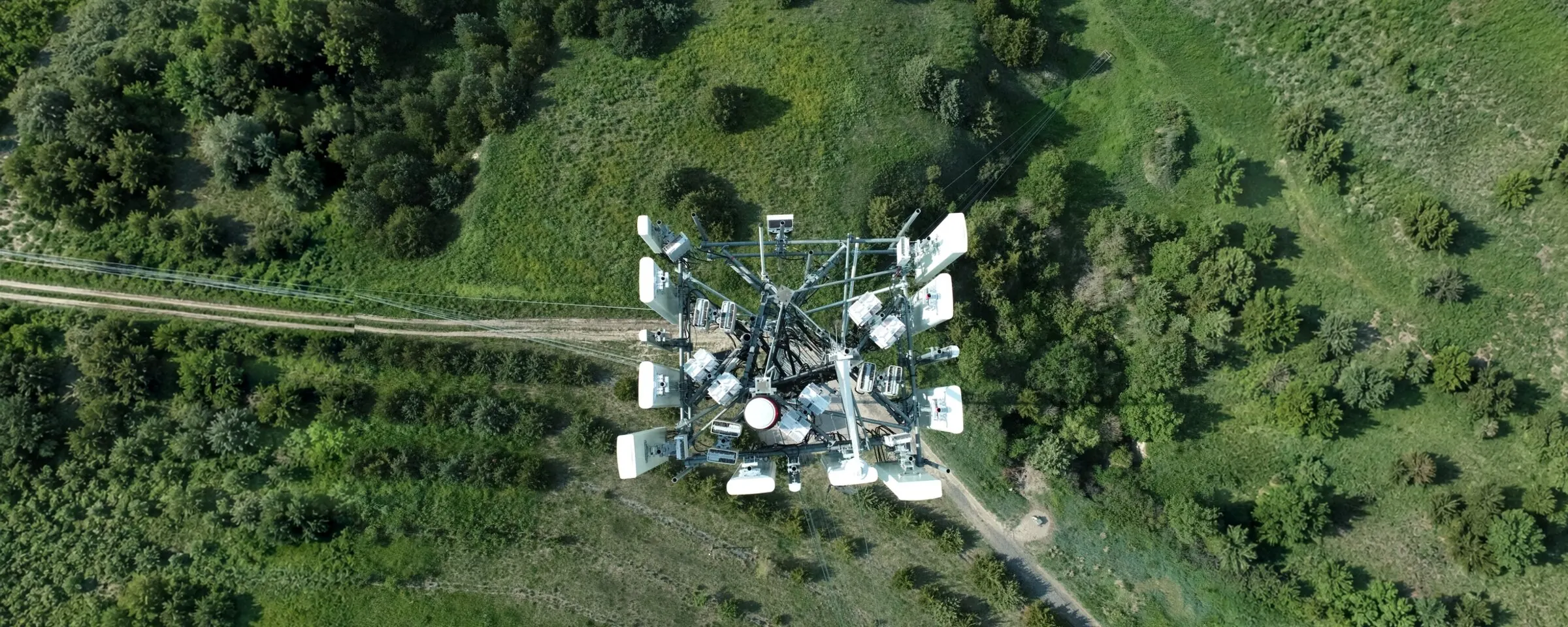 Drone photograph looking straight down on a completed telecommunications tower in open brush and grassland.